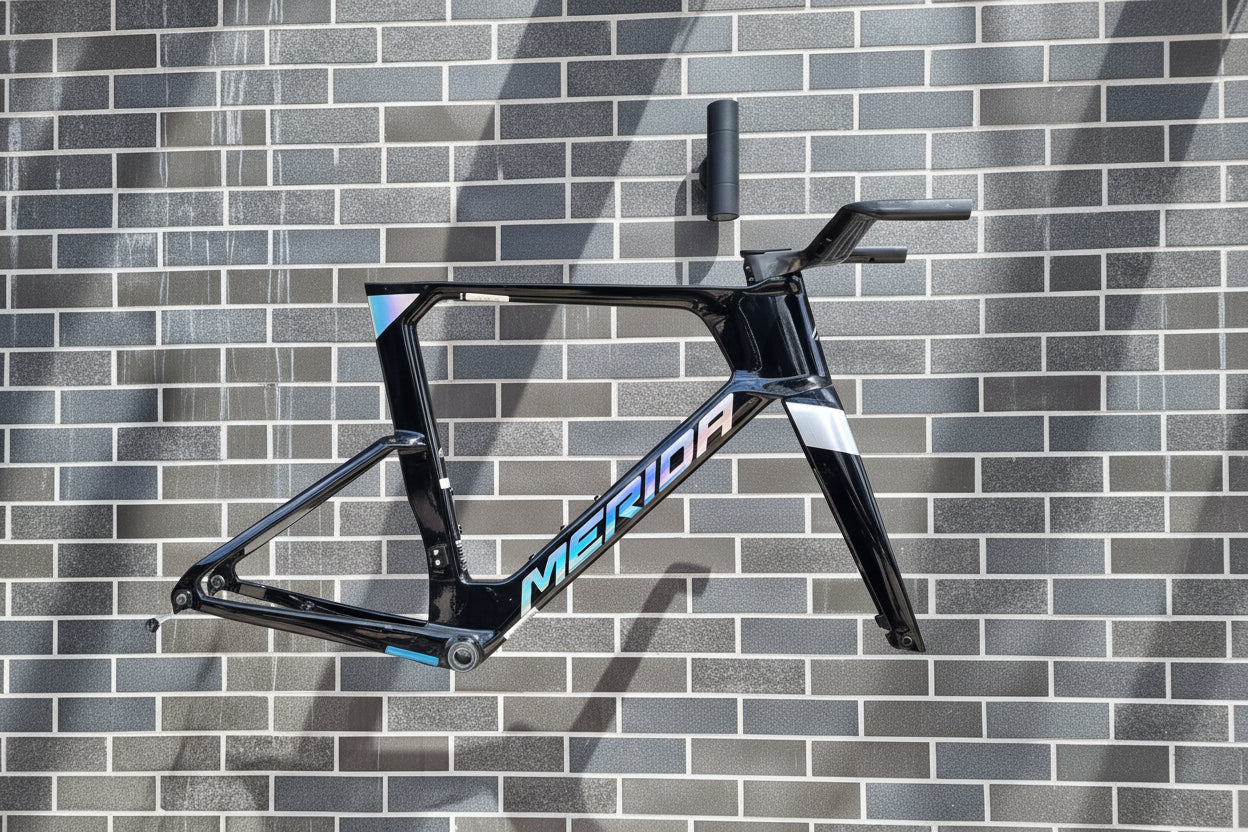 Black bicycle frame with 'Omega' branding against a tiled wall.